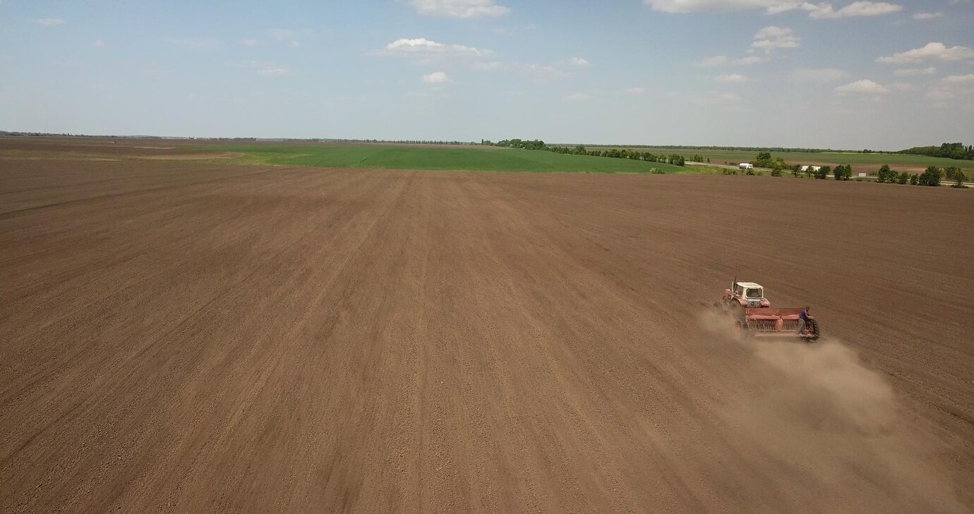 farmer-tractor-preparing-land-with-seedbed-cultivator-as-part-pre-seeding-activities-early-spring-season-agricultural-works-farmlands-drone-photo_628469-308